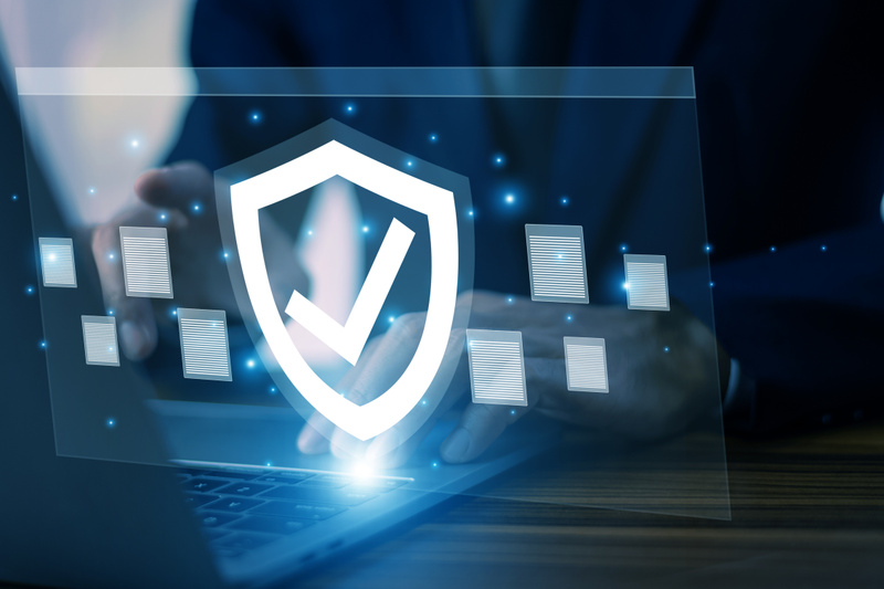 Decorative image of cyber security with computer and shield.