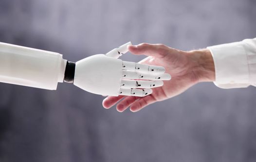 A robot hand shaking a human hand.