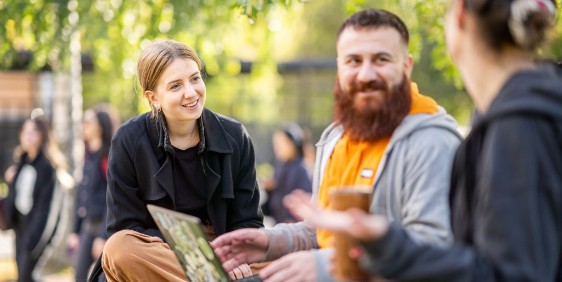 Students by a computer outdoors