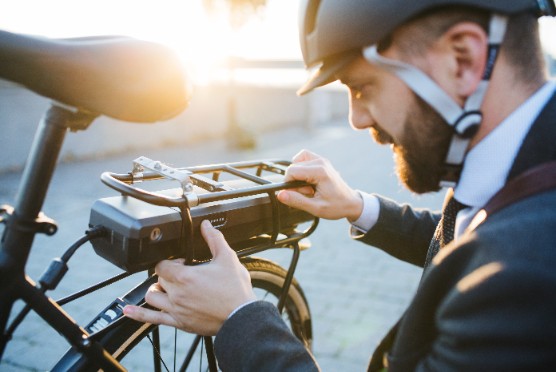a man in a beard tampering with a bicycle battery