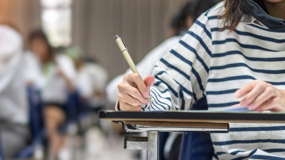 student writes on a tablet