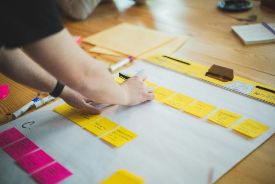 A person sticking Post-it notes onto a sheet of paper.