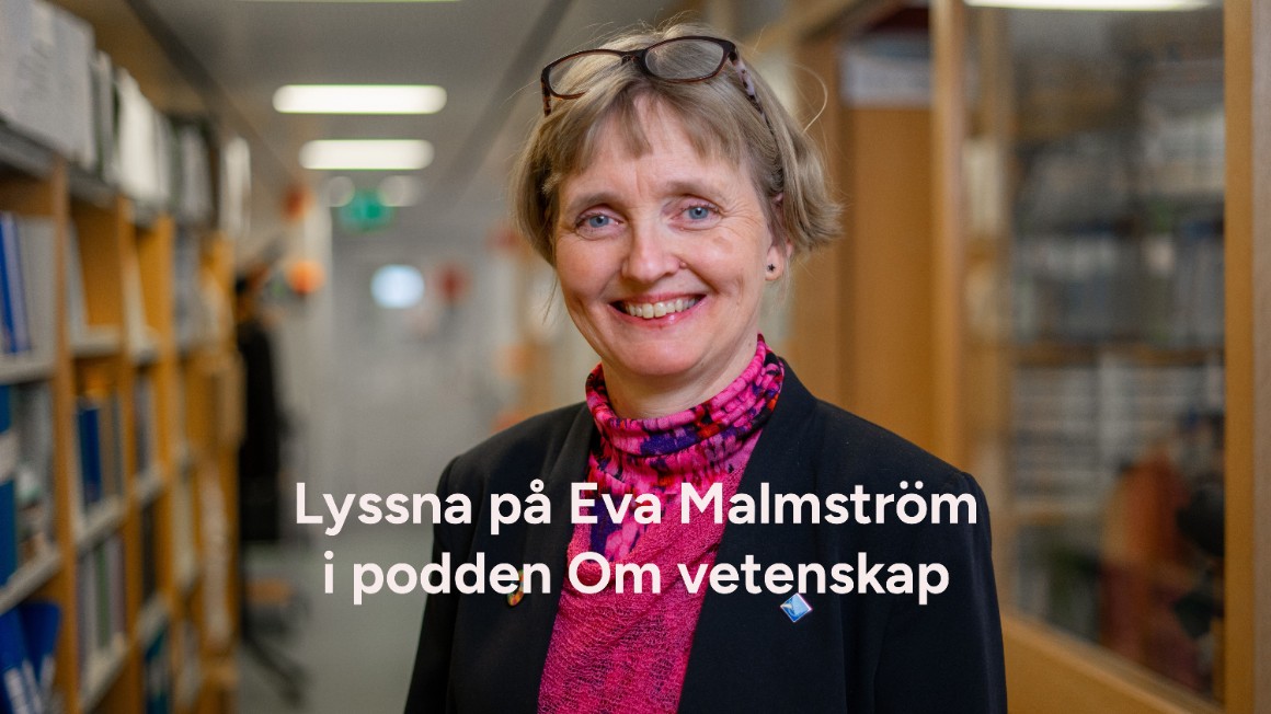Leende kvinna i kavaj stående i en korridor.