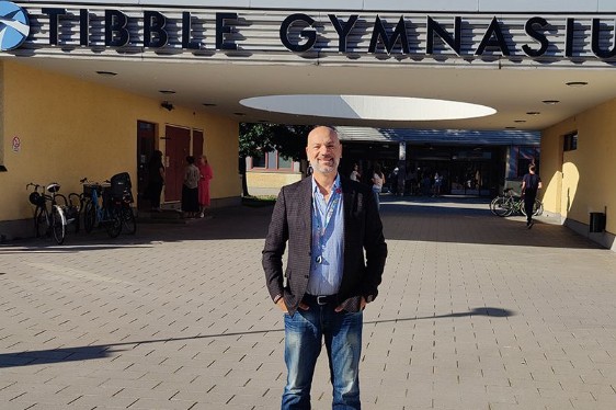 A man in front of Tibble Gymnasium