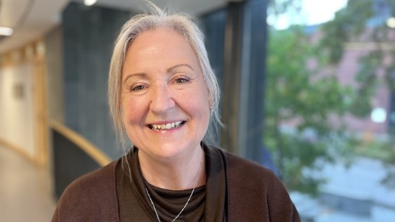 Kvinna som tittar in i kameran och ler
