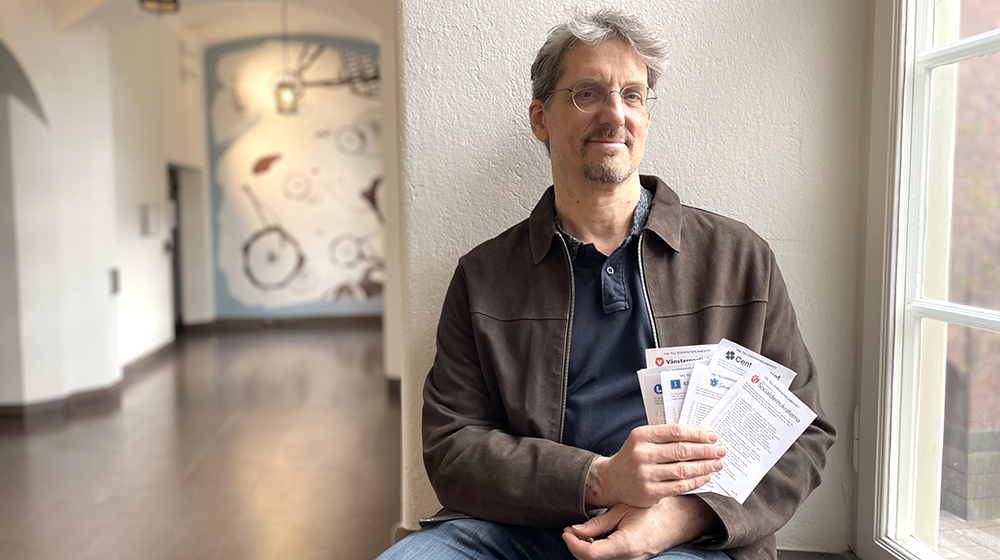 Man sitting with near a window with papers in hand