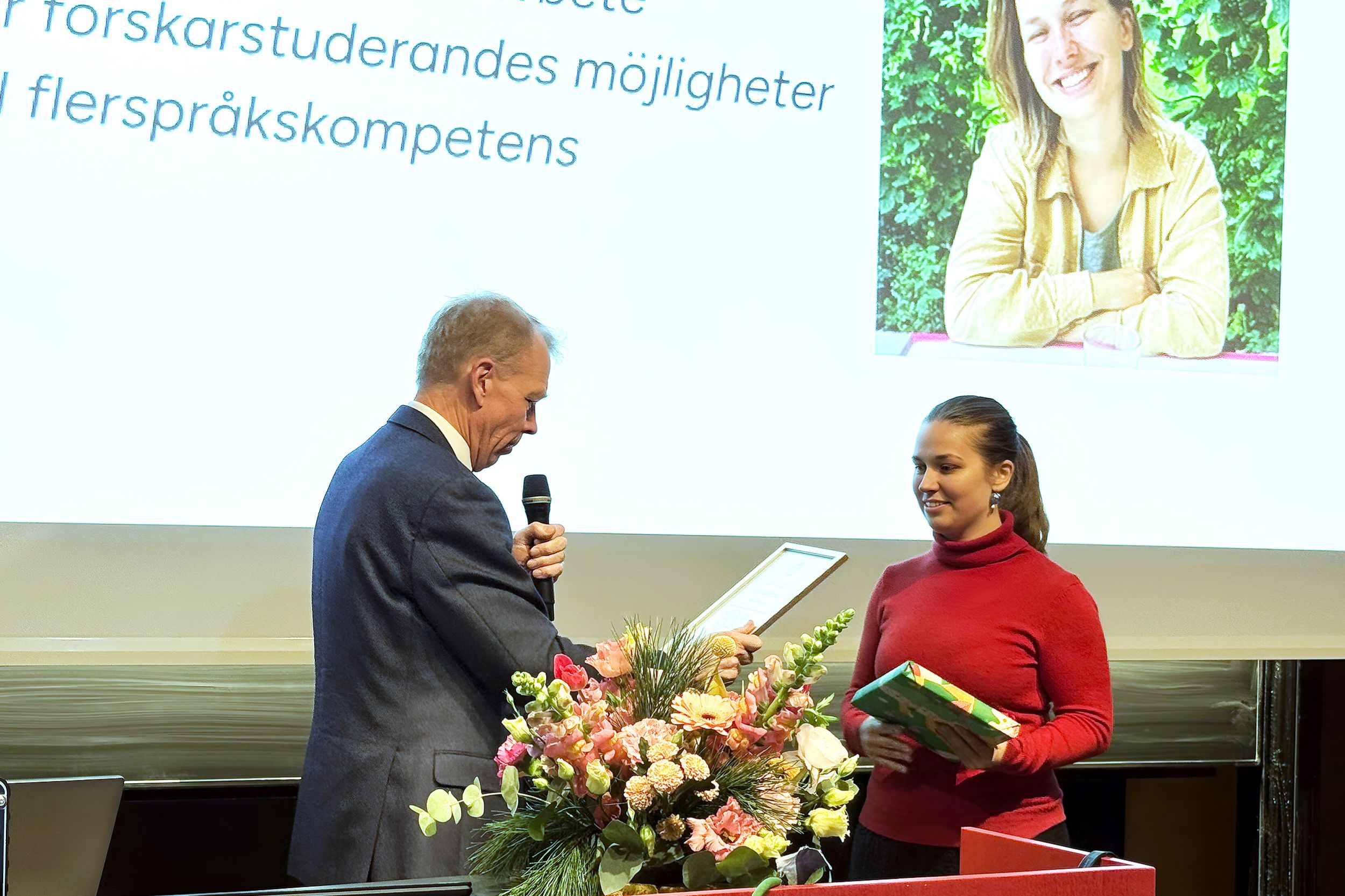A woman dressed in red receives a prize